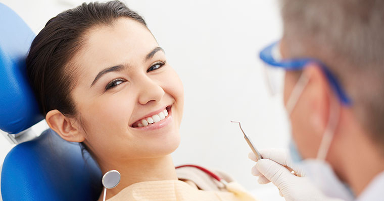 Woman in dental chair calmly smiling at dentist.
