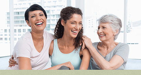 Three women off different ages smiling 