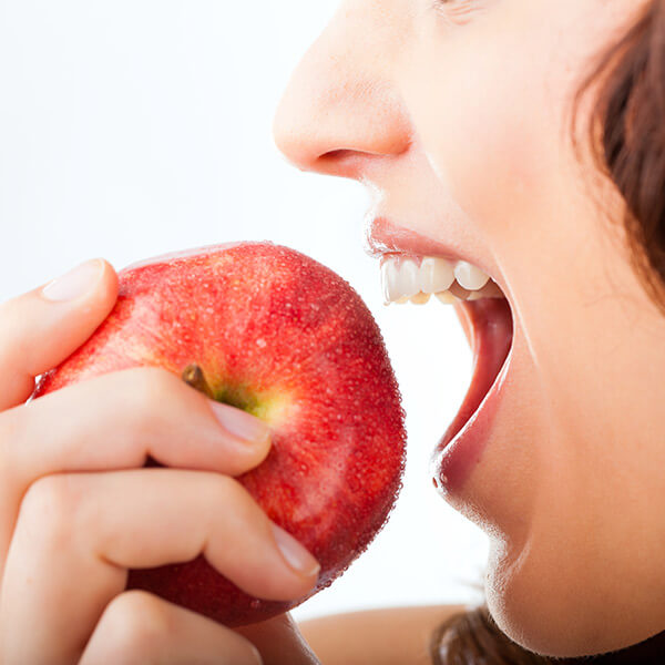 A close up of a woman bitting an apple
