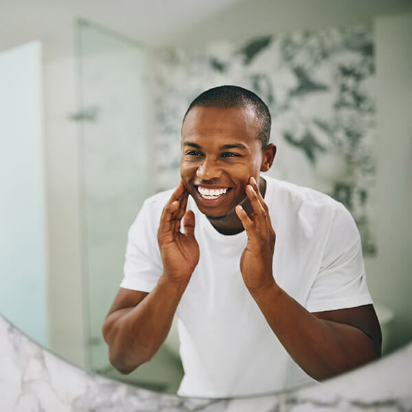 Man smiling in front of a mirror